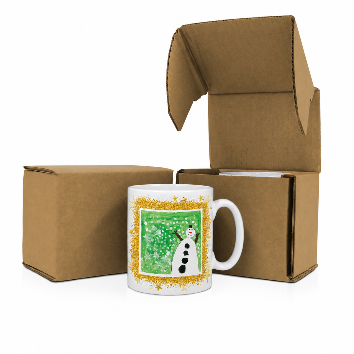 A white ceramic mug with a green winter-themed illustration of a snowman, framed by a gold glitter border, displayed in front of two brown cardboard shipping boxes on a white background.